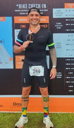 Felipe Corrêa de roupa de prova, sorrindo, com uma medalha no peito